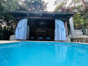 a house with a swimming pool with a gazebo at Casa Verapaz in Santa Catarina Palopó