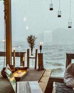 a table with a laptop on a table with the ocean at Archipelago Hideaway - Oasis on the Sea in Värmdö
