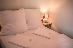 - un lit avec des oreillers blancs et une table avec une lampe dans l'établissement Haus Für 22 Personen Mit Außensauna Und Hottub, à Dahlem