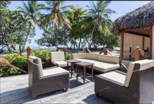 Puerto PlataMarien Residences 222 Gardenview Condo的有沙发、桌子和棕榈树的露台