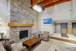 a large living room with a stone fireplace at Ski-In Ski-Out Modern Mountain Condo in Winter Park