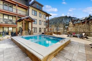 a swimming pool in the middle of a patio at Ski-In Ski-Out Modern Mountain Condo in Winter Park
