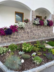 un jardín con flores al lado de un edificio en Ferienwohnung Eichhorner, en Außervillgraten