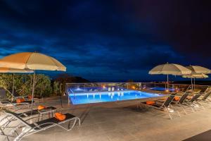 ein Swimmingpool mit Stühlen und Sonnenschirmen in der Nacht in der Unterkunft Ferienhaus für 2 Personen ca 50 qm in Algarvia, Azoren Sao Miguel in Algarvia + 32 Fotos