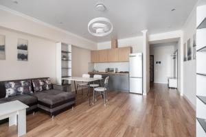 un salon avec un canapé et une table dans l'établissement One Bedroom Apartment Next To Arbat In The Heart of Almaty, à Almaty