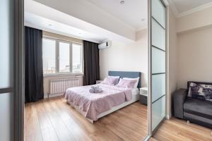 une chambre avec un lit et un grand miroir dans l'établissement One Bedroom Apartment Next To Arbat In The Heart of Almaty, à Almaty