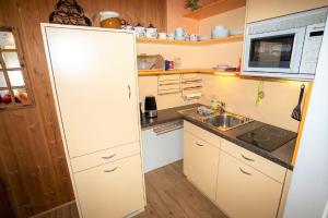 a small kitchen with a white refrigerator and a sink at Yvonne Mayer in Scuol +9 photos
