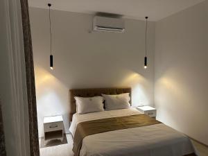 Un dormitorio con una cama grande con dos mesitas de noche. en Shatri Hotel, en Krumë