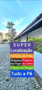 a sign sitting on a brick road in front of a building at Posada Verde Balneario Caragua in Caraguatatuba