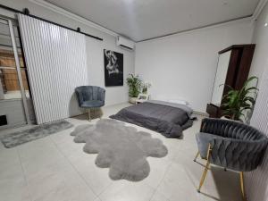 a bedroom with a bed and two chairs and a rug at suites vergel planta alta in Orizaba
