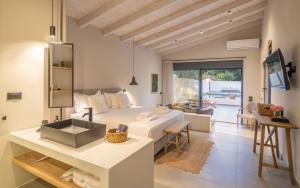 Un dormitorio blanco con una cama y una mesa. en Myrtia Villas III, en Anomeriá