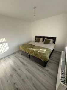 une chambre avec un grand lit dans une pièce blanche dans l'établissement Blackthorne House, à Birmingham