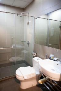 a bathroom with a toilet and a sink and a shower at Inn86 in Bintulu