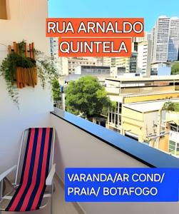 une chaise sur un balcon avec vue sur une ville dans l'établissement Quarto com Anfitrião RJ, à Rio de Janeiro