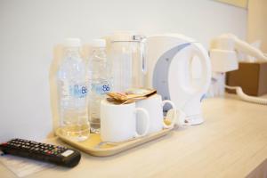 a counter with bottles of water and a remote control at Inn86 in Bintulu