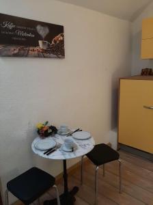 una mesa pequeña en una habitación con 2 sillas en Am Schlosspark, en Ilmenau