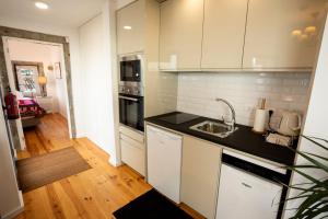 eine Küche mit weißen Schränken und einer Spüle in der Unterkunft Ferienhaus für 2 Personen ca 43 qm in Algarvia, Azoren Sao Miguel in Algarvia