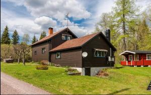 ein Haus auf einem Grasfeld neben einer Straße in der Unterkunft Ein großes Haus am Wald mit Bach für 8 Personen 