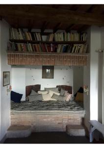 - une chambre avec un lit et une étagère de livres dans l'établissement Hochwertige Wohnung Im Turm Schlösschen, à Montemerano 13 autres photos
