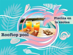 two drinks on a wooden table next to a pool at Great condo with pool in Punta Cana