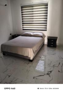 una camera da letto con un letto, pavimenti in marmo e una finestra di Casa Bella Mansion a Nariño