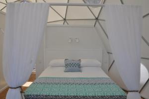 a small bed in a room with curtains at Mile End Glamping Pty Ltd in Yelverton