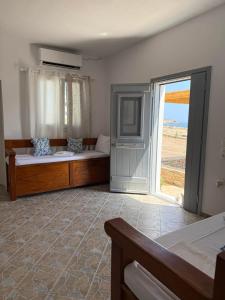 1 Schlafzimmer mit 2 Betten und einer Glasschiebetür in der Unterkunft AMBELI Luxury Apartment in Schinoussa