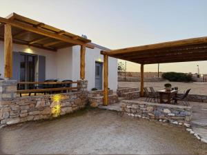 eine Terrasse mit einem Tisch und einer Steinmauer in der Unterkunft AMBELI Luxury Apartment in Schinoussa