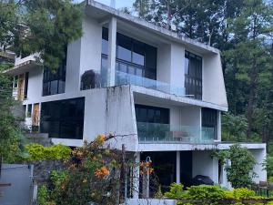 a white building with a balcony and trees at Casa Verapaz in Santa Catarina Palopó