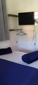 un lit dans une chambre avec une télévision et un casque audio dans l'établissement SUITES E CHALES PRIVADOS Rock's&Rose's home, à Camburi 170 autres photos