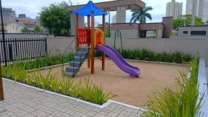 a playground with a slide in the sand at Aptos completos em prédio com piscina a 400m da Praia de Piçarras - BACs in Piçarras