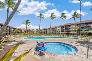 a pool at a resort with palm trees at Papakea B201 · PK B201 Updated Condo w Ocean View in Kahana