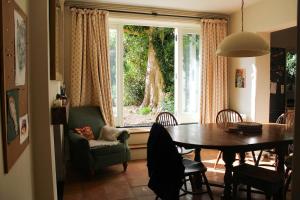 刘易斯4-bedroom Lewes Sauna House - Modern Interiors, Castle Views的一间有桌子、椅子和窗户的餐厅