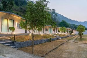 uma fila de casas com árvores à sua frente em Traverse Riverside Resort Rishikesh em Rishikesh mais 21 fotografias