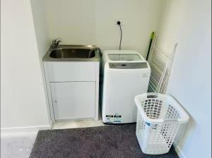 基督城2 Bedroom townhouse with garage close to Hagley Park, Westfield Mall, Railway Station, Hospital and Wolfbrook Arena的带水槽和洗衣机的小厨房