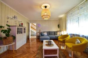 uma sala de estar com um sofá azul e cadeiras amarelas em Dalmatinisches Landhaus Martin em Otok mais 31 fotografias