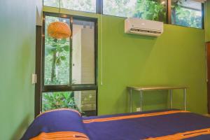 Cette chambre verte comprend un lit et une fenêtre. dans l'établissement Avellanas Private Villa, à Santa Cruz 32 autres photos
