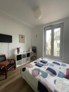a bedroom with a bed and a chair and a window at LE 84 in Le Mans