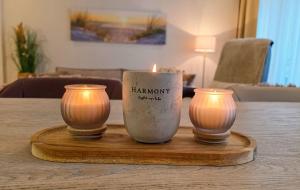 two candles sitting on a wooden tray on a table at Amadeus Loft in Wilhelmshaven