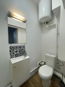 a white bathroom with a toilet and a sink at LE 84 in Le Mans