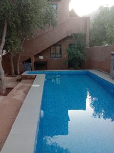 a large blue swimming pool in front of a building at la maison mondiale ouirgane in Ouirgane +48 photos