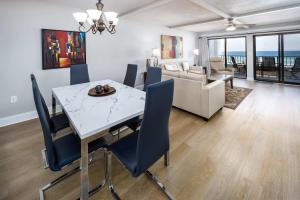 una sala da pranzo con un tavolo bianco e sedie blu di Surf Dweller 309 Large gulf front condo a Fort Walton Beach