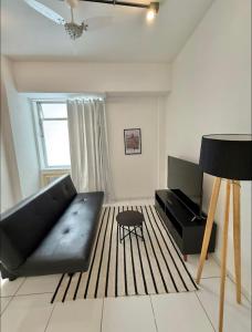 een woonkamer met een zwarte bank en een tafel bij Centro - Divino apartamento in Rio de Janeiro