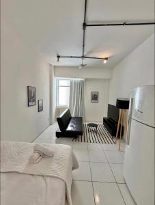 een witte woonkamer met een bank en een koelkast bij Centro - Divino apartamento in Rio de Janeiro