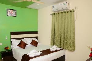 a bedroom with two beds and a green wall at Royal Residency in Pedappai +24 photos