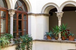 un bâtiment avec des plantes en pot sur un rebord de fenêtre dans l'établissement Palazzo Malfatti Zwei Zimmer Wohnung Für Zwei Personen, à Massa Marittima