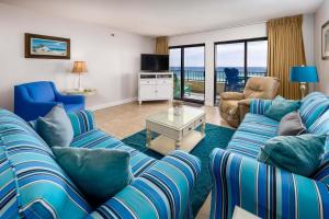 a living room with blue couches and a view of the ocean at Surf Dweller 312 Large gulf front in Fort Walton Beach
