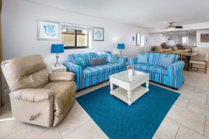 a living room with two blue couches and a table at Surf Dweller 312 Large gulf front in Fort Walton Beach