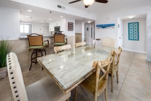 a dining room with a glass table and chairs at Surf Dweller 312 Large gulf front in Fort Walton Beach +27 photos