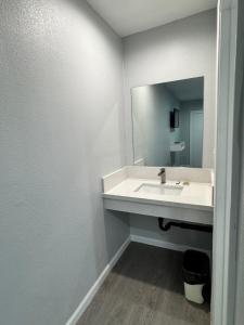 ein Badezimmer mit Waschbecken und Spiegel in der Unterkunft Angel's Motel near Anaheim in Orange